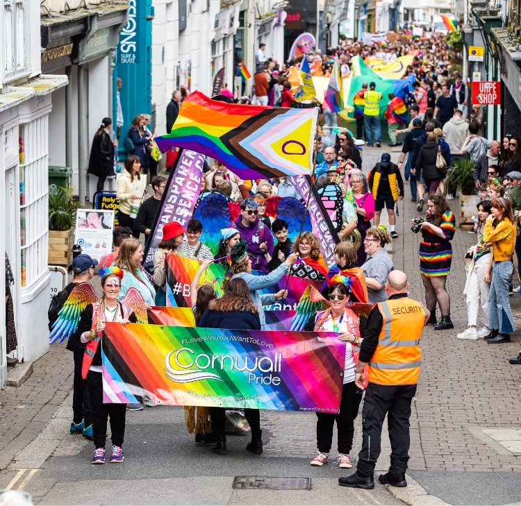 pride march taking place with volunteers, security detail and supporters